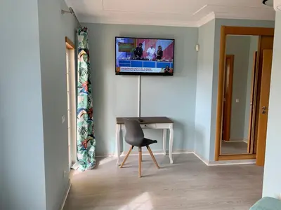 a room with a desk and a television on a wall at Villa Adrian & Brian in Albufeira