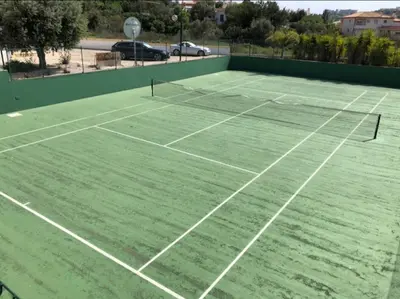 a tennis court with two tennis rackets on it at Villa Adrian & Brian in Albufeira