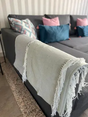 a gray couch with pillows and a blanket on it at Villa Adrian & Brian in Albufeira