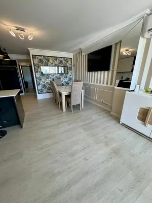 a living room with a table and chairs and a kitchen at Villa Quévin in Albufeira