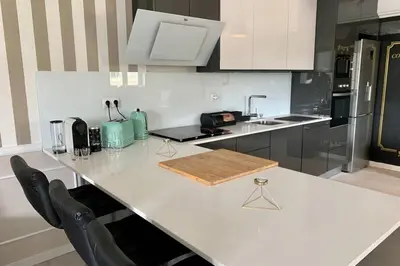 a kitchen with a white counter and black appliances at Villa Quévin in Albufeira