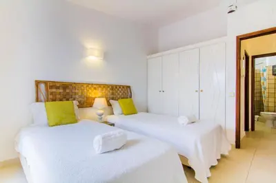 a bedroom with two beds with white sheets and green pillows at Villa 2, great spot Oura beach, Albufeira in Albufeira