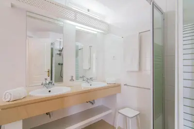 a white bathroom with two sinks and a shower at Villa 2, great spot Oura beach, Albufeira in Albufeira