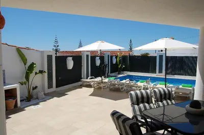 a patio with a table and chairs and a pool at Villa 2, great spot Oura beach, Albufeira in Albufeira