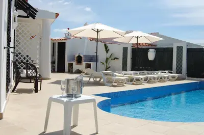 a patio with a row of chairs and a pool at Villa 2, great spot Oura beach, Albufeira in Albufeira
