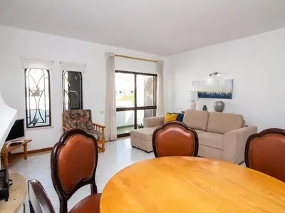 a living room with a table and a couch at Areias Apartment by Stay ici Algarve Holiday Rental in Albufeira