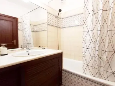 a bathroom with a sink and a shower with a tub at Areias Apartment by Stay ici Algarve Holiday Rental in Albufeira