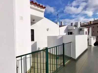 a white building with a green fence on a balcony at Areias Apartment by Stay ici Algarve Holiday Rental in Albufeira