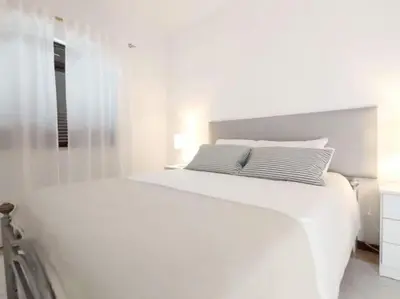 a white bedroom with a large white bed in it at Areias Apartment by Stay ici Algarve Holiday Rental in Albufeira