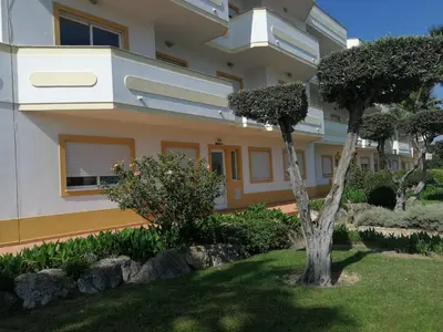 a house with a tree in the front yard at Jardim Paraiso Apartments in Albufeira