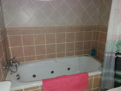 a bath tub in a bathroom with a pink towel at Jardim Paraiso Apartments in Albufeira