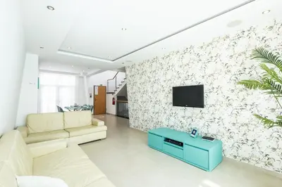a living room with a couch and a tv on a wall at Villa Orada in Albufeira