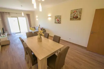 a dining room with a wooden table and chairs at Marina Garden Apartment in Albufeira