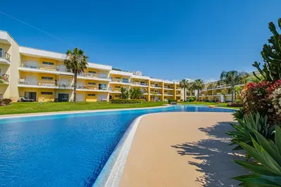 a swimming pool in front of a building at Marina Garden Apartment in Albufeira