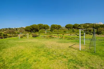 an empty field with two soccer nets in the grass at Marina Garden Apartment in Albufeira