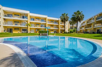 a large swimming pool in front of a building at Marina Garden Apartment in Albufeira