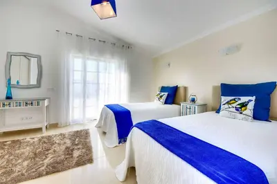 a bedroom with two beds and a window at Villa Machado in Albufeira