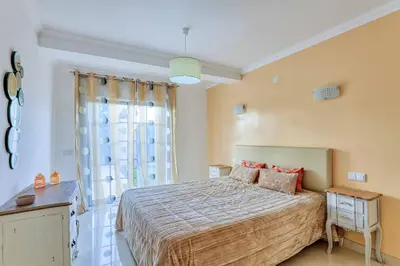 a bedroom with a bed and a large window at Villa Machado in Albufeira