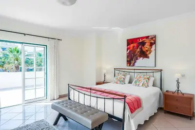a bedroom with a bed and a large window at Villa Minerva in Albufeira