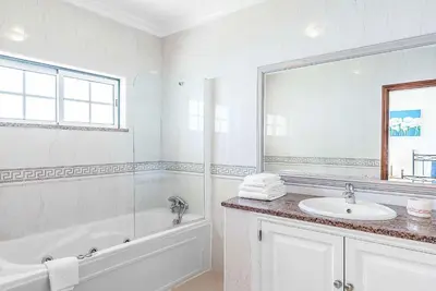 a white bathroom with a tub and a sink at Villa Minerva in Albufeira