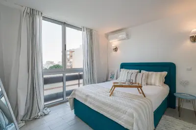 a bedroom with a blue bed and a large window at Serenity by the Marina, Vilamoura in Quarteira