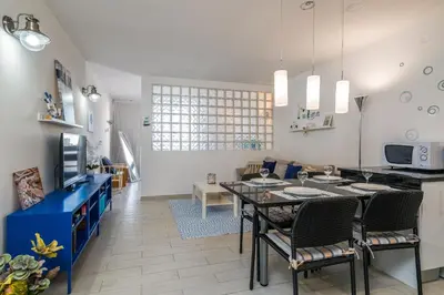 a kitchen and living room with a table and chairs at Serenity by the Marina, Vilamoura in Quarteira