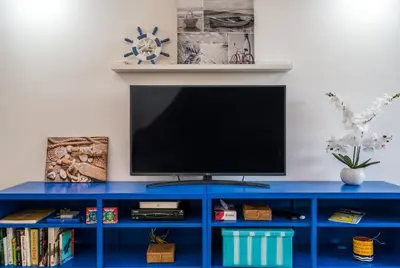 a blue entertainment center with a flat screen tv on top at Serenity by the Marina, Vilamoura in Quarteira