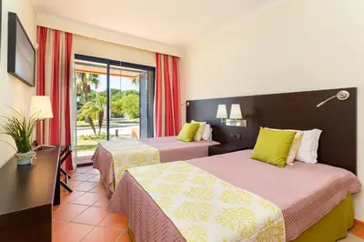 a hotel room with two beds and a window at AL - Apartamento Vila Sol F5 E in Vilamoura