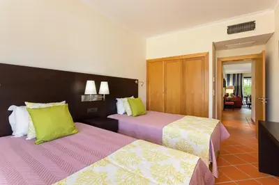 a hotel room with two beds with green and pink at AL - Apartamento Vila Sol F5 E in Vilamoura