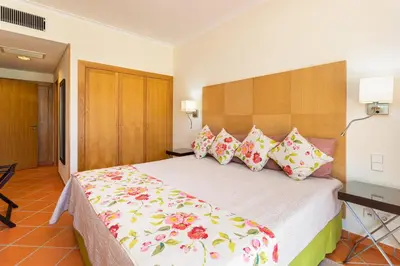 a bedroom with a large bed with colorful pillows at AL - Apartamento Vila Sol F5 E in Vilamoura