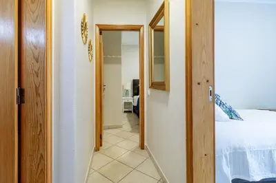 a hallway leading to a bedroom with a bed and a mirror at Top renoviertes Apartment mit großer Terrasse in Albufeira
