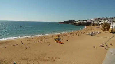 a group of people on a beach with the ocean at Top renoviertes Apartment mit großer Terrasse in Albufeira