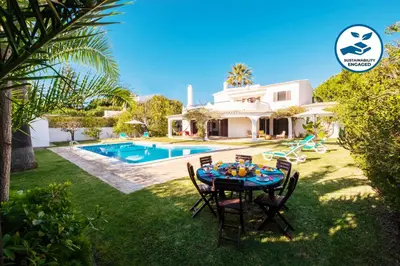 a table in the yard of a house with a pool at Villa Atlas by Algarve Vacation in Albufeira