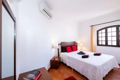 a bedroom with a large white bed with red pillows at Villa Atlas by Algarve Vacation in Albufeira