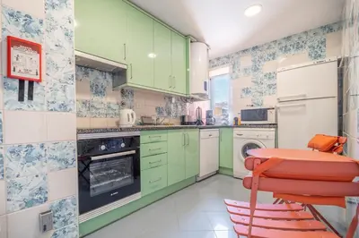 a kitchen with green cabinets and a red stool at Marina Design T1 in Albufeira