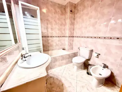a bedroom with a large bed and a window at Vila Columbus T2 Frente Mar e Piscina in Quarteira