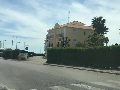 a building sitting on the side of a street at Vila Columbus T2 Frente Mar e Piscina in Quarteira