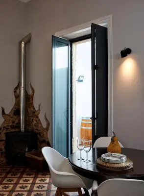 a dining room with a table and chairs and a fireplace at Pereiras House of Charm - Downtown in Faro