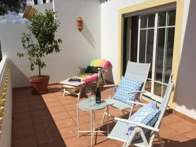 a patio with chairs and a table and a couch at Paradise Beach Villa in Albufeira
