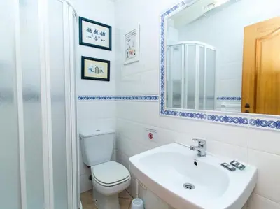 a bathroom with a toilet and a sink and a mirror at Joia da Galé House by Stay ici Algarve Holiday Rental in Albufeira