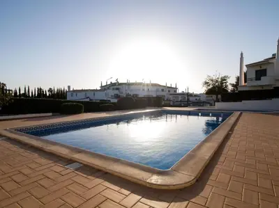 a swimming pool in a yard with buildings in the background at Joia da Galé House by Stay ici Algarve Holiday Rental in Albufeira