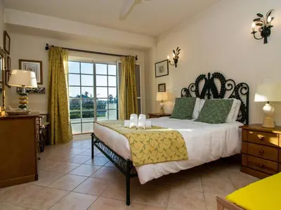 a bedroom with a large bed and a large window at Joia da Galé House by Stay ici Algarve Holiday Rental in Albufeira
