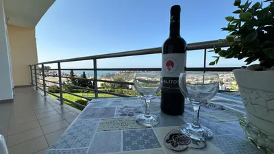 a bottle of wine and two glasses on a table at Apartamento Costa in Albufeira