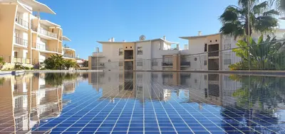 a swimming pool in front of some apartment buildings at Apartamento Costa in Albufeira