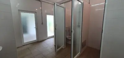 a bathroom with a toilet and sliding glass doors at Apartamento Costa in Albufeira