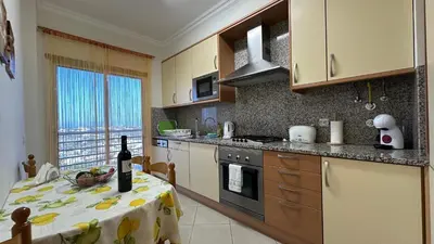 a kitchen with a table with a bottle of wine at Apartamento Costa in Albufeira