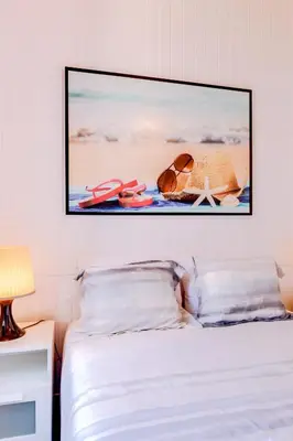 a bedroom with a bed with a picture on the wall at TREM - LOCATED IN OLD CITY - FARO in Faro