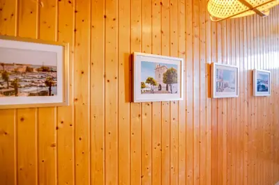 a wall with three pictures on a wooden wall at TREM - LOCATED IN OLD CITY - FARO in Faro