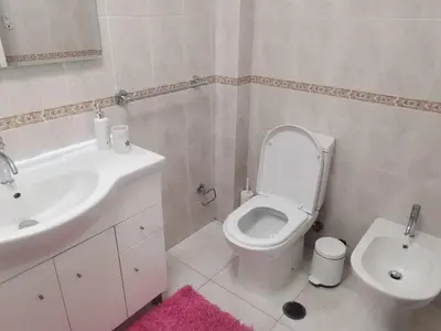 a bathroom with a white toilet and a sink at Penha House in Faro