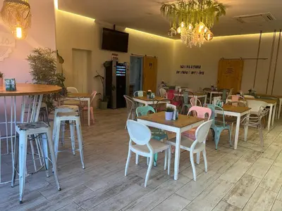 a restaurant with tables and chairs and a chandelier at Penha House in Faro